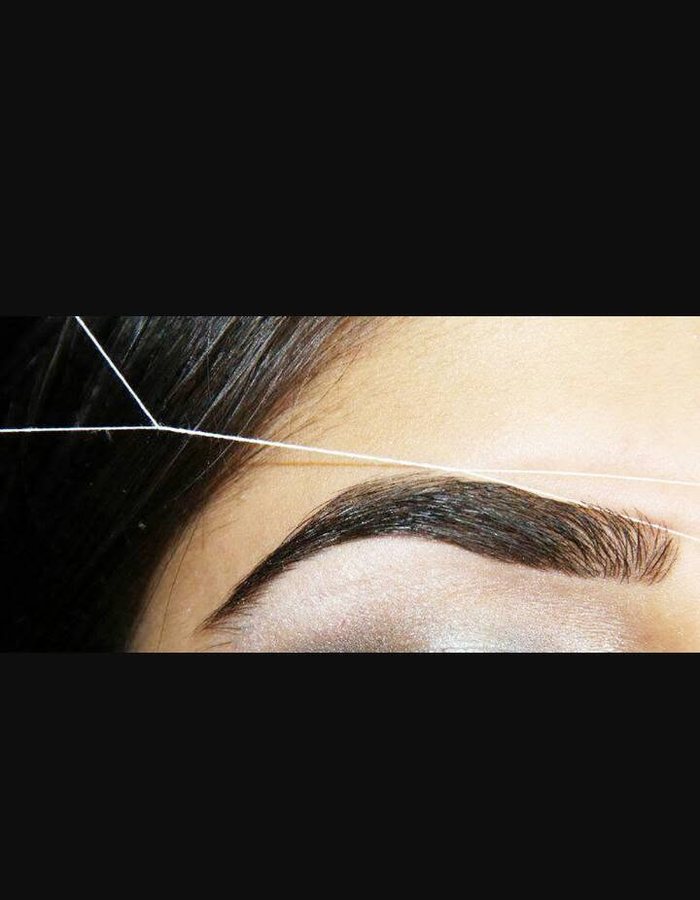 Close-up brow shaping detail for threading and waxing services